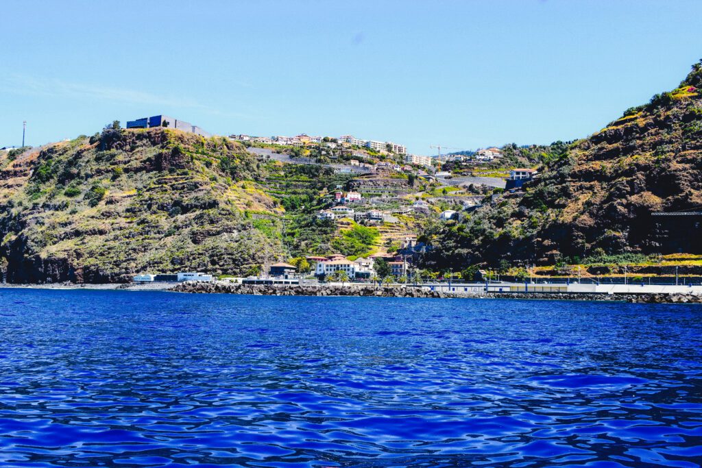 Zuidkust van Madeira met helderblauw water en een zandstrand.