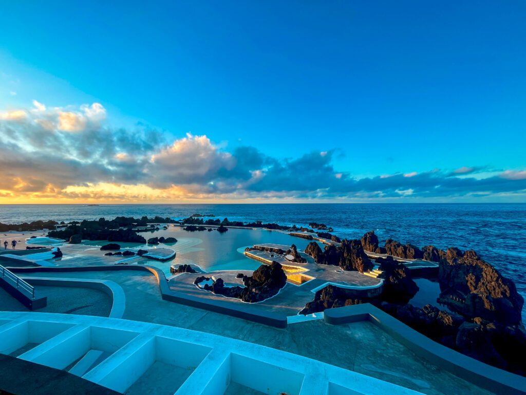 panoramische foto over de piscinas naturais do porto moniz. Deze gedeeltelijk aangelegde zwembaden zijn gevuld met zeewater, maar zijn afgewerkt zodat kinderen er veilig kunnen spelen en zwemmen. Het oogt als een groot zwembad op de rand van oceaan.