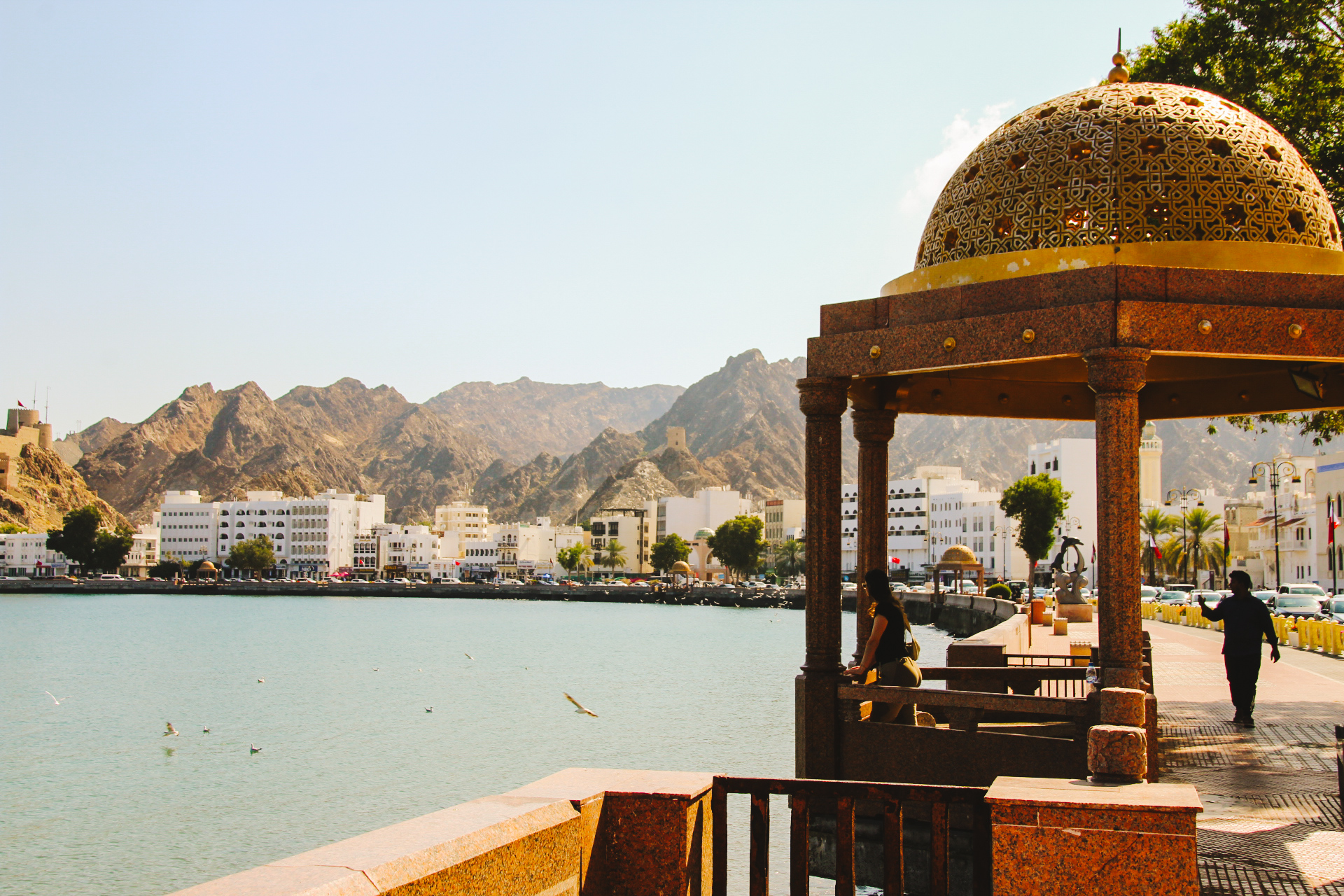 Lotte kijkt uit over de haven aan de corniche van Muscat, Oman.