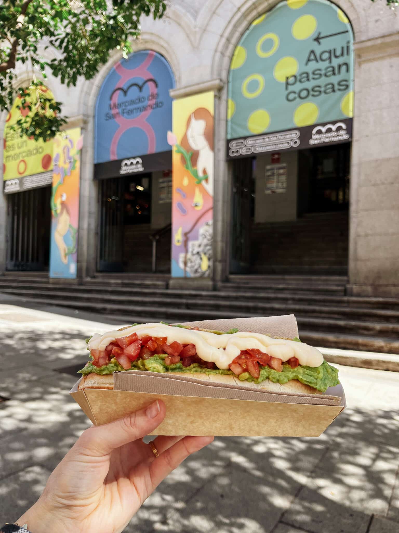 Hotdog van Mercado de San Fernando, Madrid, Spanje. Op de hotdog ligt avocado, tomaat en mayonaise.