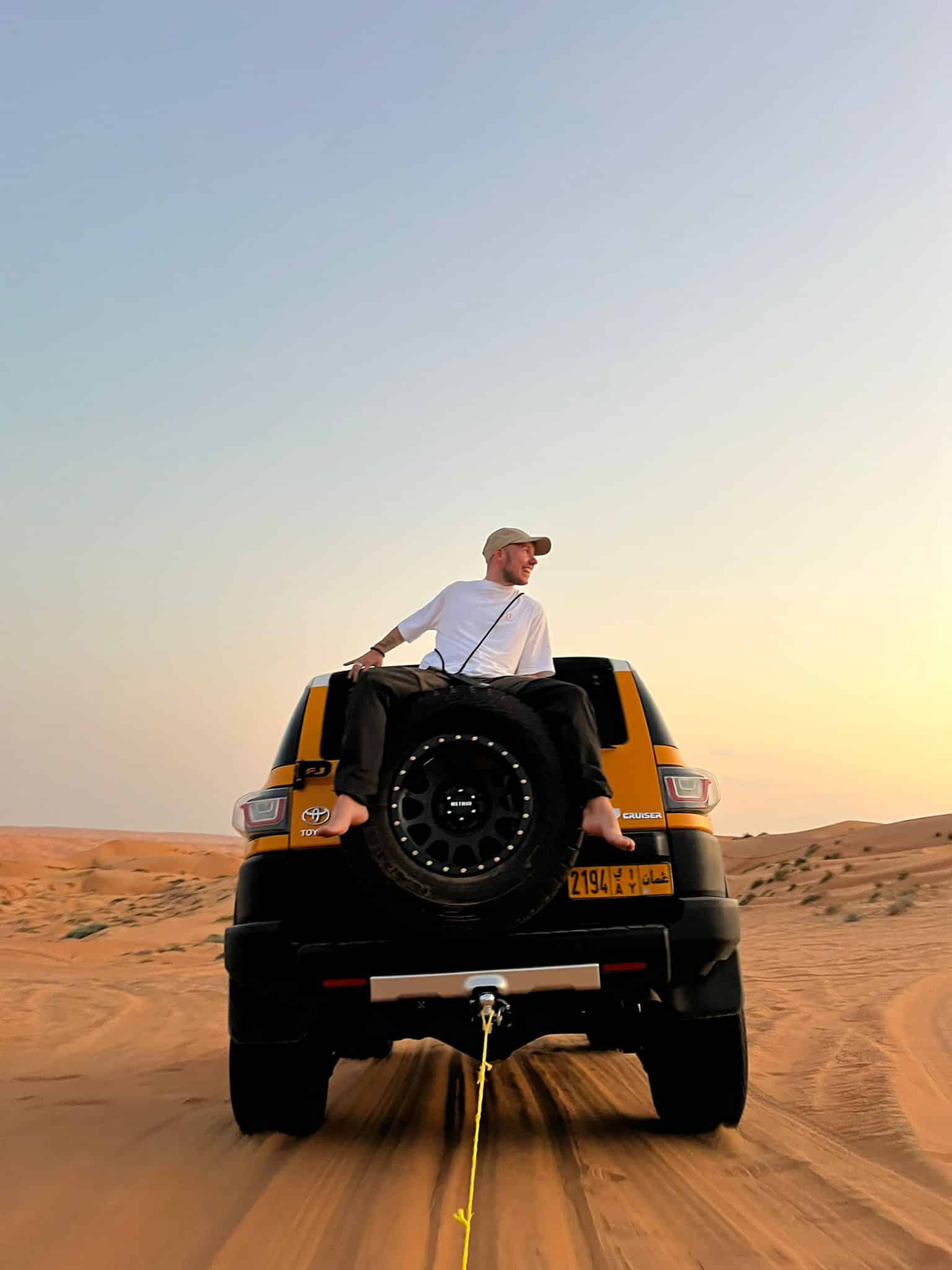 Davo zit achterop de 4x4 in Wahiba Sands, Oman.
