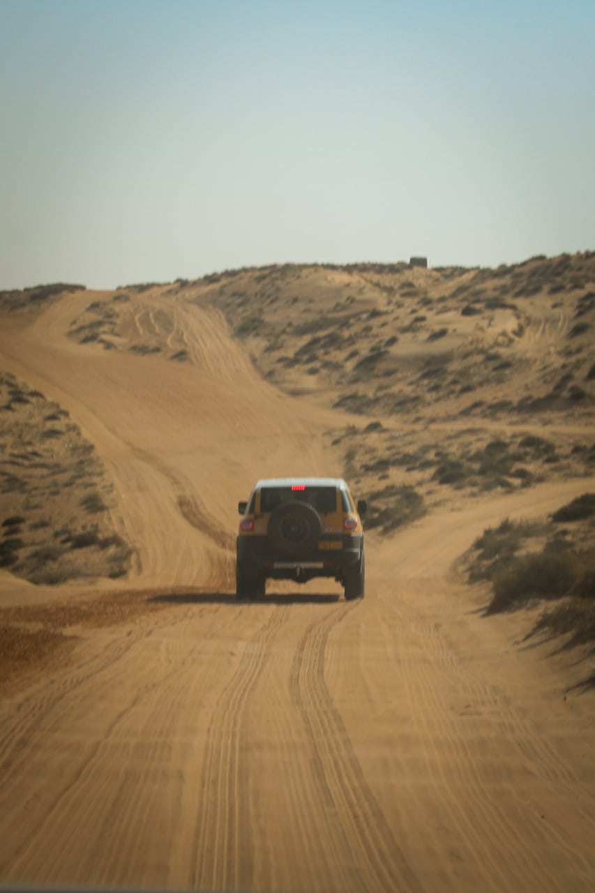 4x4 rijdt voor ons in de duinen van Wahiba Sands, de woestijn in Oman.