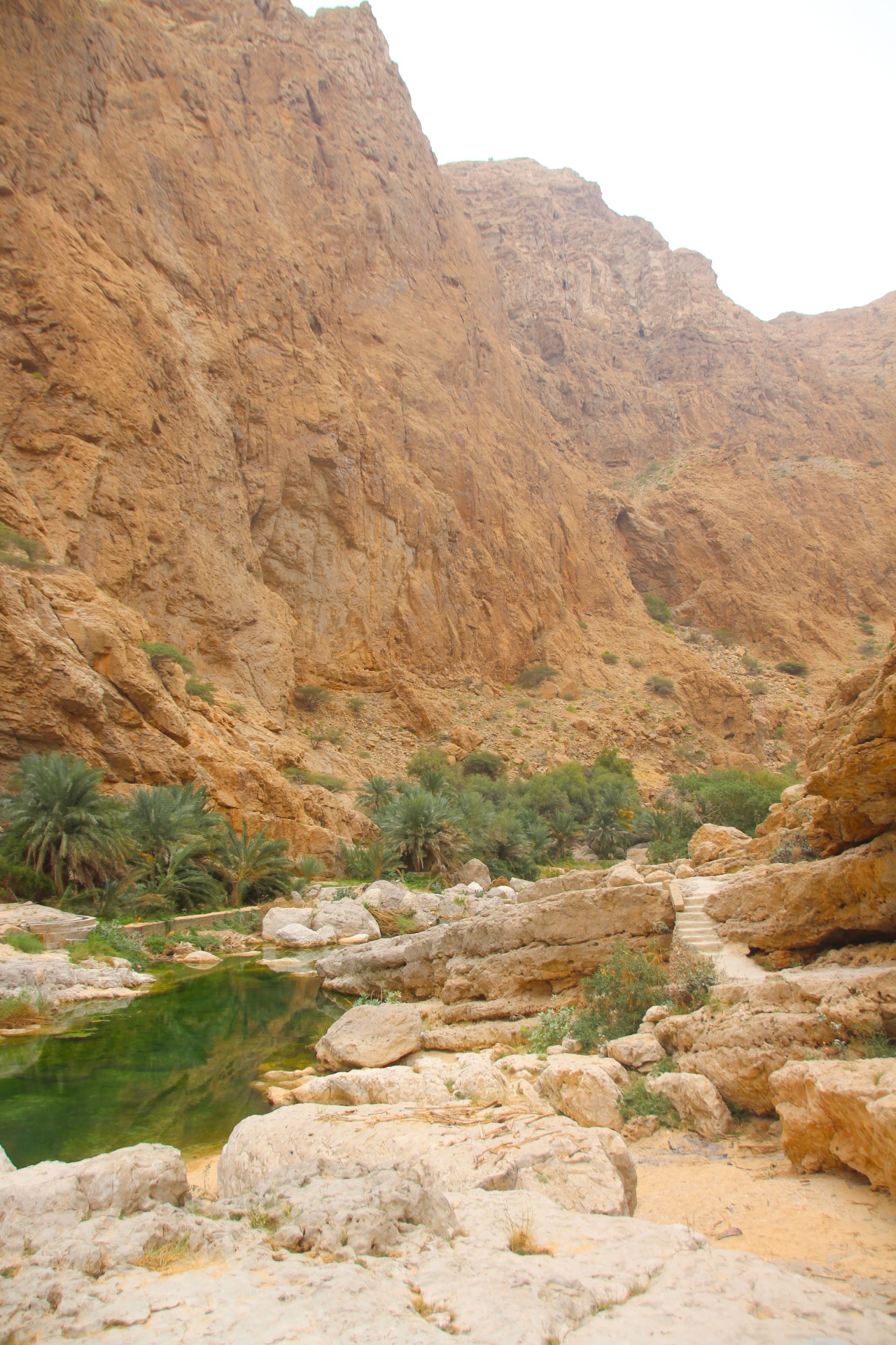 Goudgele rotsen omringen wadi shab in Oman.