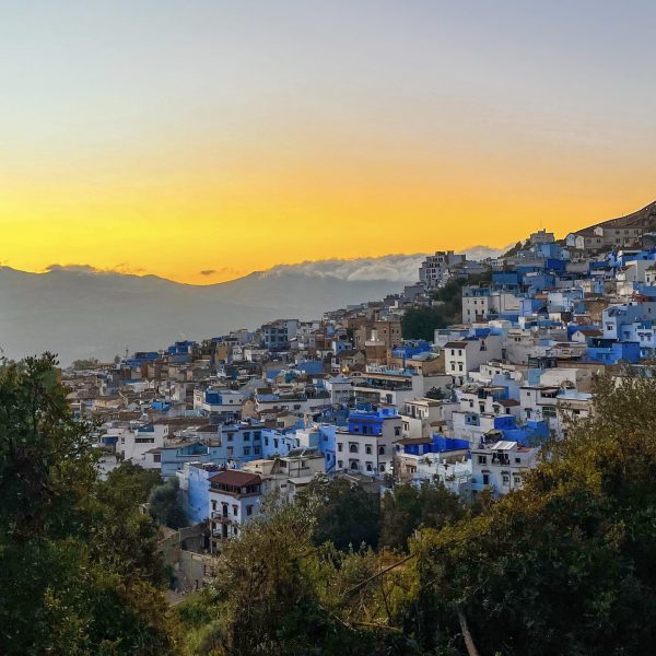 De zon verdwijnt achter het dorpje Chefchaouen in het Rifgebergte, Marokko.